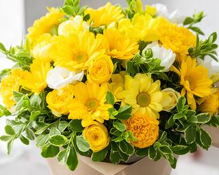 Bright cheerful bouquet with yellow flowers and fresh green foliage