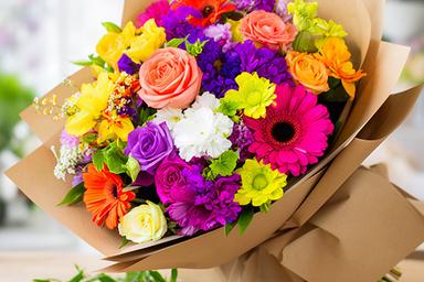 Colourful congratulations bouquet wrapped in natural paper