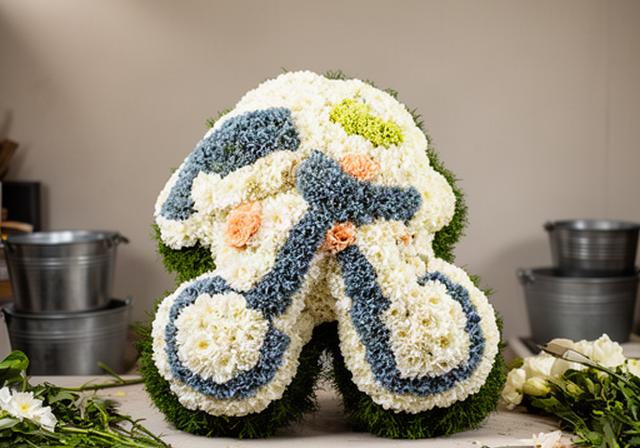 Personalised floral tribute shaped around a favourite hobby, arranged in a quiet florist studio
